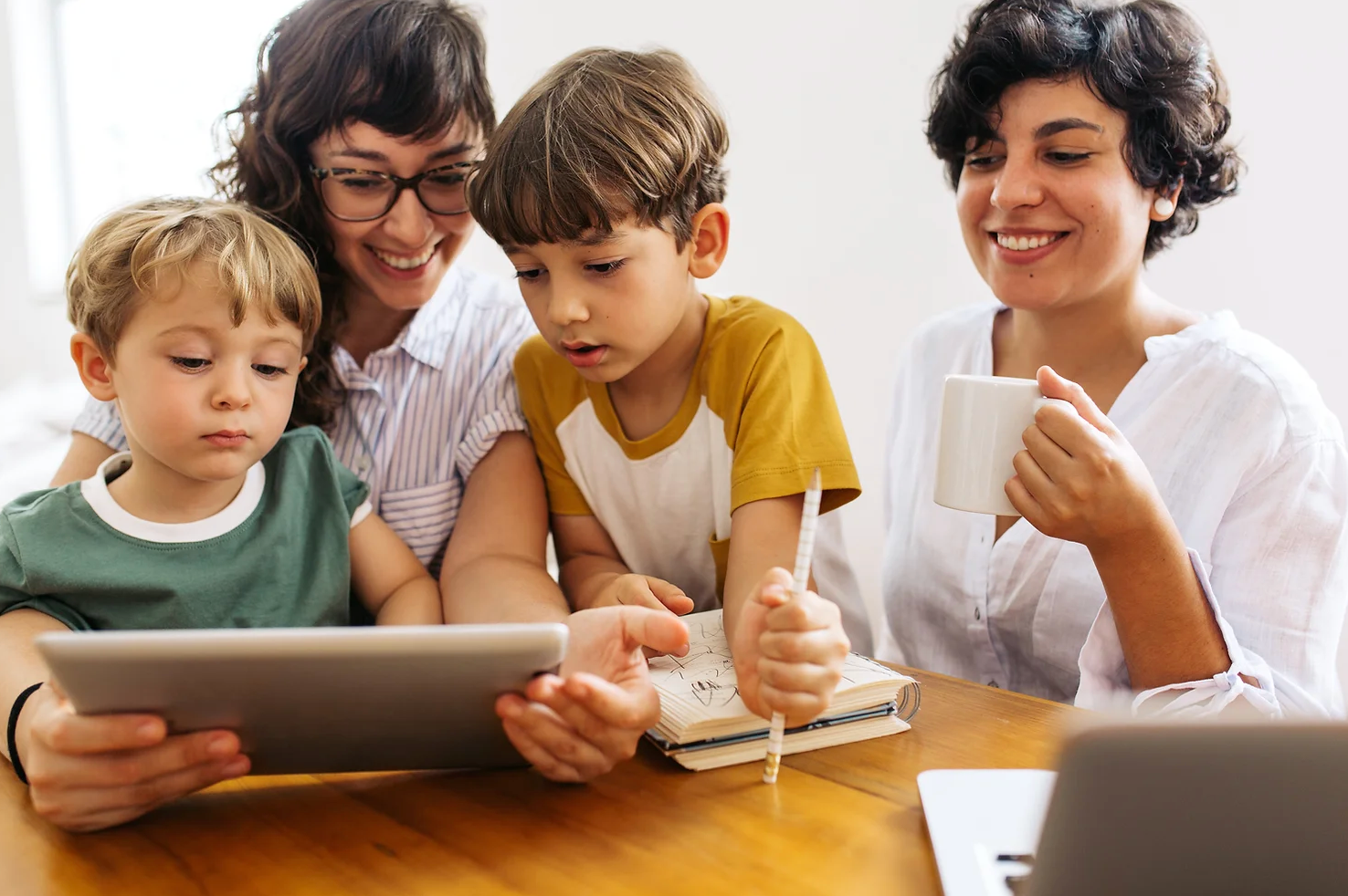 two women and two young buys looking at a digital tablet screen - Family is for everyone